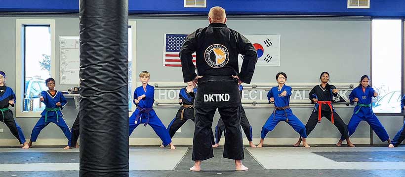 Instructor leading students in Taekwondo practice at DK Fitness Arts.