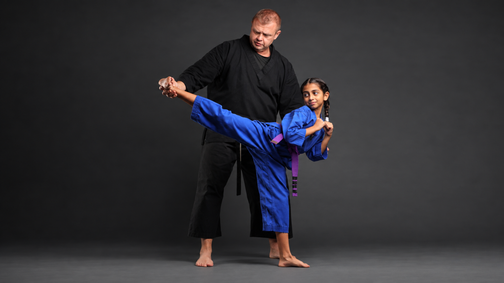 DKFA instructor guiding a student through a Taekwondo kick