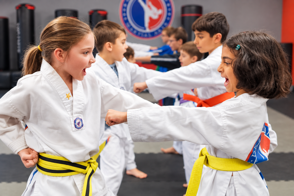 Taekwondo students practice a controlled partner technique during class at DK Fitness Arts.