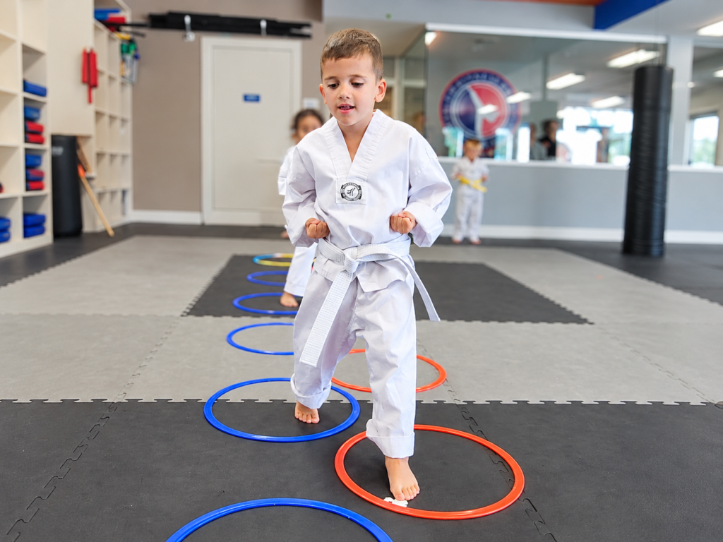 Tiger Tots student stepping through colorful hoops during a coordination activity.